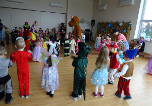 Dzieci przebrane za różne postaci tańczą.