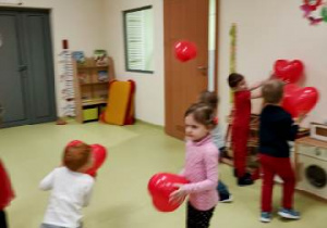 Dzieci bawią się balonami w kształcie serca.