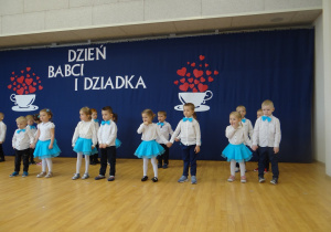 Dzieci tańczą, trzymając się za ręce.