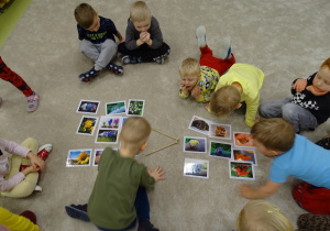 Dzieci zaznaczają znak mniejszości do znaczków z obrazkami.