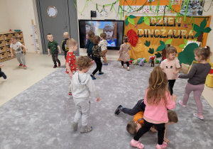 Dzieci chodzą po sali naśladując dinozaury