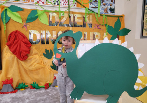 Oluś pozuje z dinozaurem w fotobudce