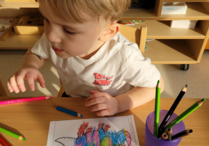 Franio koloruje ilustrację dinozaura