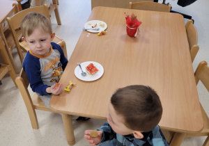 Dzieci jedzą ciasto przy stolikach
