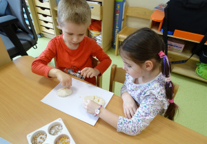 Dzieci ozdabiają swoje ciasteczka soczewicą, słonecznikiem.