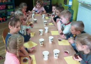 Dzieci jedzą muffinki przy stole
