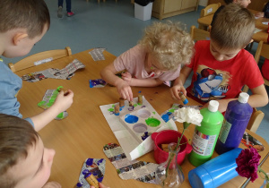 12 Dzieci ozdabiają farbami i korkiem papierowe skarpetki