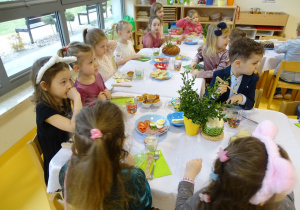 Dzieci siedzą przy stole wielkanocnym