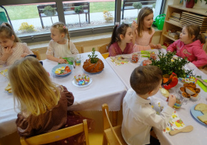 Dzieci siedzą i rozmawiają przy stole