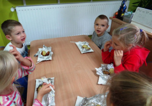 Dzieci jedzą przy stole