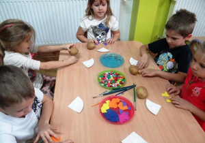 Dzieci wybierają kolorowe dodatki do gąsienicy