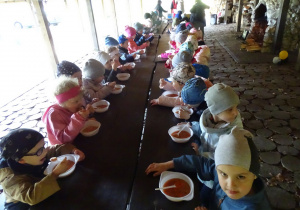 dzieci jedzą zupę