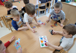 Dzieci kolorują skarpetki z gazet