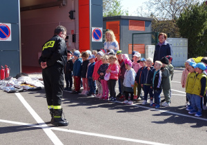 Strażak opowiada dzieciom o swojej pracy