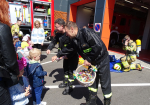 Dzieci wręczają strażakom laurkę