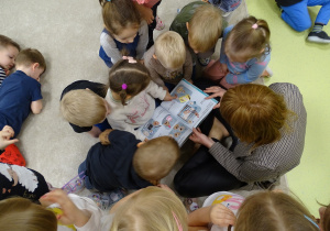 Dzieci oglądają książkę.