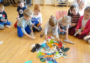 Dzieci wybierają ubranka dla swoich króliczków.