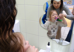 Pani stomatolog pokazuje Ewie jak myć zęby