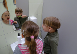 Dzieci myją zęby przed lustrem