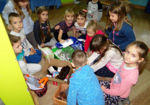Dzieci układają zebrane przedmioty recyklingowe