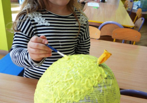 Dziewczynka maluje balon - słońce