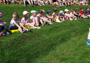 Dzieci siedzą na trawie