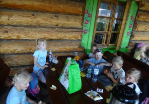Dzieci jedzą przy stołach