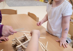 Dzieci układają wieże z patyczków
