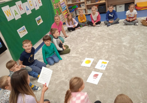 Dzieci rozwiązują zagadki czytane przez nauczyciela.