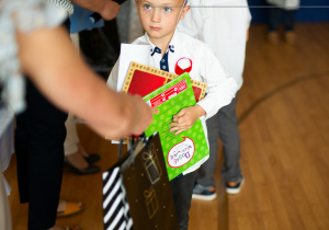 Mikołaj odbiera dyplom i nagrodę.