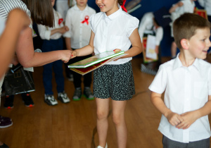 Amelka odbiera dyplom i nagrodę.