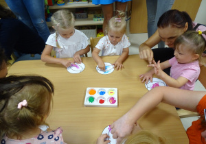 Dziewczynki malują palcami piłkę