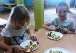Dzieci prezentują gotowe szaszłyki z owoców