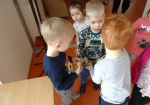 Dzieci pokazują sobie znalezione czekoladowe jajeczka.