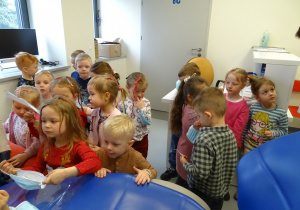 Dzieci oglądają akcesoria stomatologiczne.
