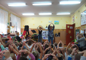 Dzieci trzymają ręce nad głowami
