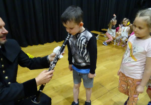 Chłopiec dmucha w klarnet.