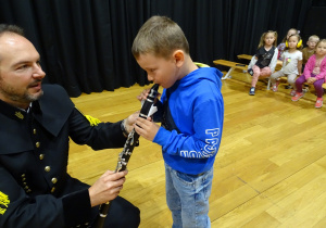 Chłopiec dmucha w klarnet.
