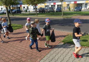 dzieci idą chodnikiem