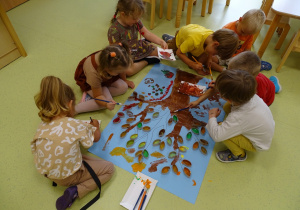 Dzieci malują farbami kolorowe liście