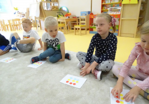 Dzieci wykonują zadanie z kolorowymi kropkami.