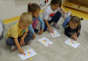 Dzieci wykonują zadanie z kolorowymi kropkami.