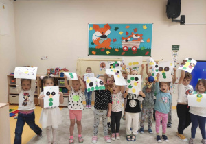 Dzieci pozują do zdjęcia ze swoimi pracami.