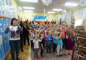 Dzieci tańczą z rękami wzniesionymi do góry