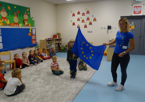 Pani pokazuje flagę Unii Europejskiej