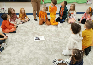 Dzieci oglądają zdjęcie Papieża Jana Pawła II i słuchają informacji na temat Papieża.