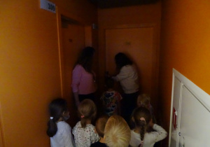 Dzieci z panaimi wchodzą do pokoju hotelowego.