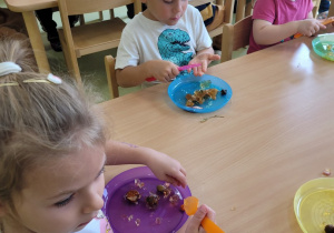 Dzieci bawią się galaretką wyłożoną na talerzyki