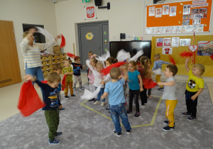 12 Dzieci tańczą z białymi i czerwonymi chusteczkami