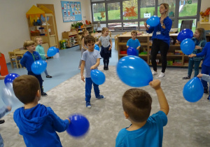 dzieci trzymają niebieskie balony